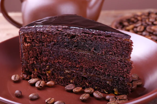 Köstlicher Schokoladenkuchen mit Kaffeebohnen auf dem Teller aus nächster Nähe — Stockfoto