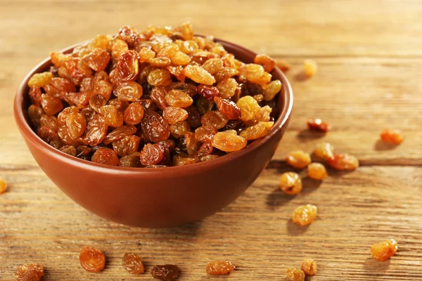 Raisins in ciotola su tavolo di legno, primo piano — Foto Stock