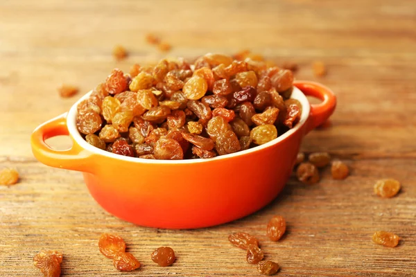 Raisins in pan on wooden table, closeup — Stock Photo, Image