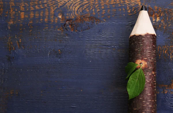 Lápiz de madera con hoja sobre fondo de madera — Foto de Stock