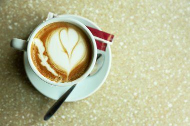Fincan cappuccino'nin kalbinde kafede masada köpük ile