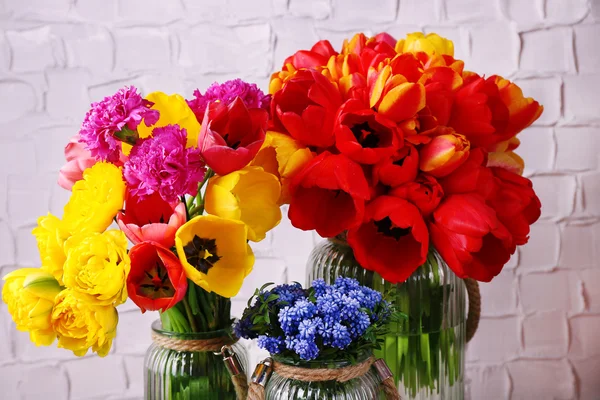 Beautiful flowers in vases on wall background — Stock Photo, Image