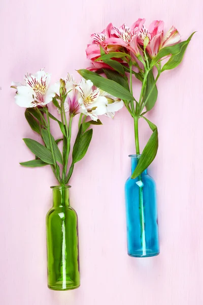 Beautiful alstroemeria in vases on wooden background — Stock Photo, Image