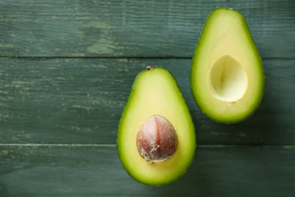 Sliced avocado on wooden background — Stock Photo, Image