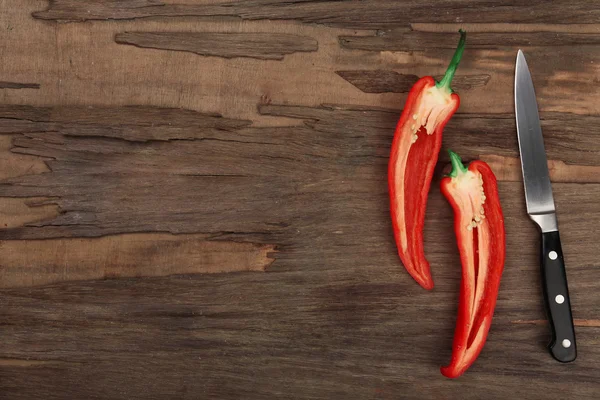 Poloviny pepř chilli s nožem na dřevěné pozadí — Stock fotografie