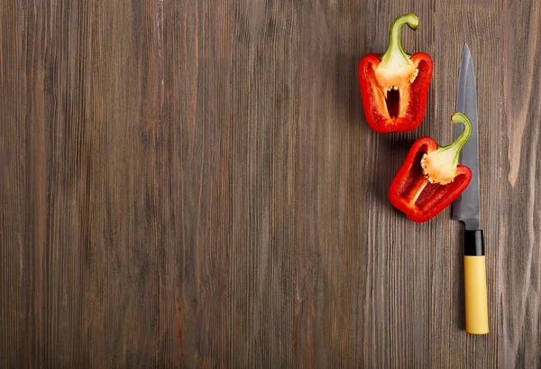 Moitiés de poivre avec couteau sur fond en bois — Photo