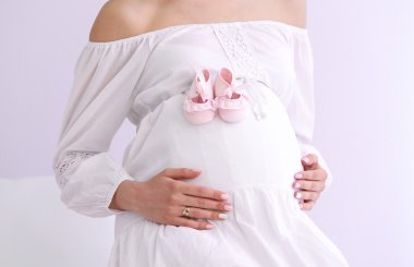 Bebek Patik beyaz duvar arka plan üzerinde olan hamile kadın