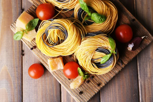 Rohe Pasta mit Käse und Gemüse auf Holzgrund — Stockfoto