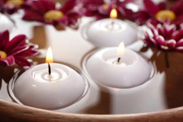 Tigela de água termal com flores e velas, close-up — Fotografia de Stock