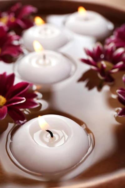 Cuenco de agua de spa con flores y velas, primer plano — Foto de Stock