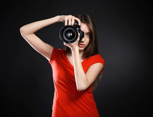 Jovem fotógrafa tirar fotos em fundo preto — Fotografia de Stock