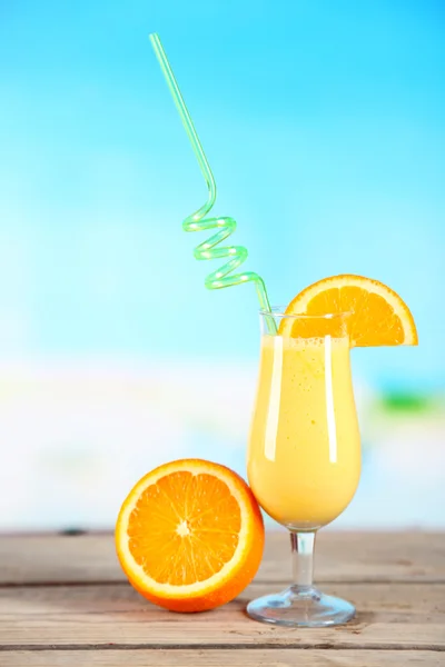 Glass of summer cocktail on wooden table on bright blurred background — Stock Photo, Image