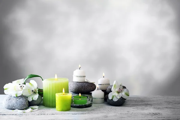 Hermosa composición con velas y piedras de spa sobre fondo claro — Foto de Stock