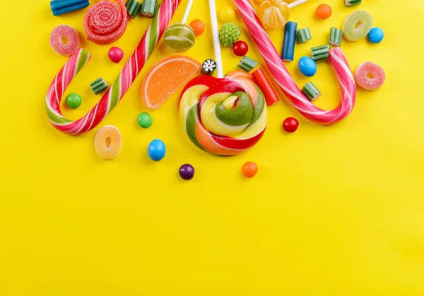 Colorful candies on yellow background — Stock Photo, Image