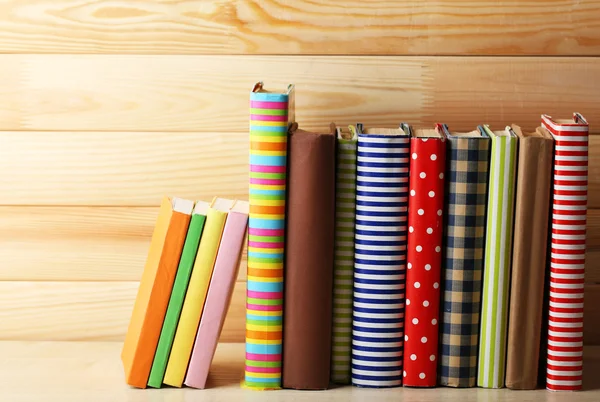 Libri su scaffale, primo piano, su sfondo di legno — Foto Stock