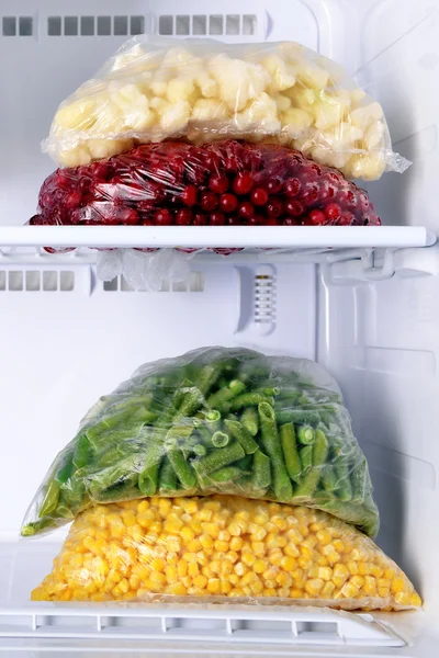 Frozen berries and vegetables in bags in freezer close up — Stock Photo, Image