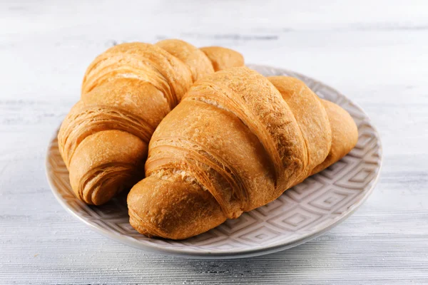 Delicious croissants on plate on table close-up — Stock Photo, Image