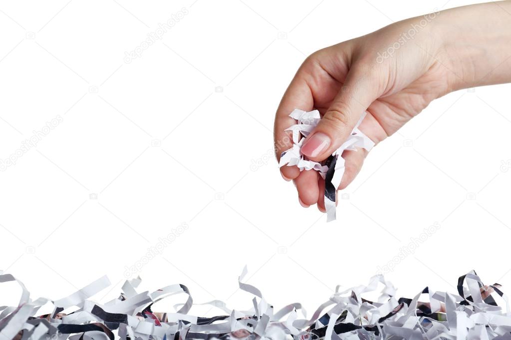 Strips of destroyed paper from shredder in female hand isolated on white