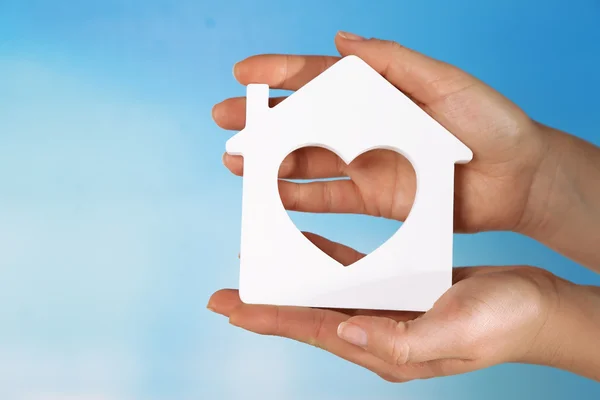 Female hands with model of house on color background — Stock Photo, Image