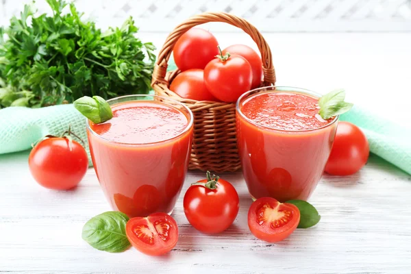 Gläser mit frischem Tomatensaft auf Holztisch, Nahaufnahme — Stockfoto