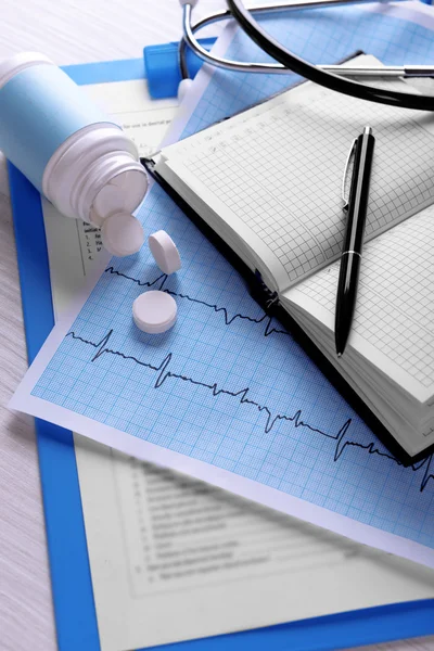Cardiograma com comprimidos na mesa, close-up — Fotografia de Stock