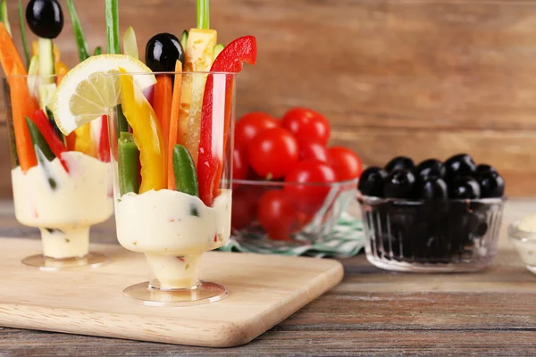 Snack van groenten in glaswerk op houten achtergrond — Stockfoto