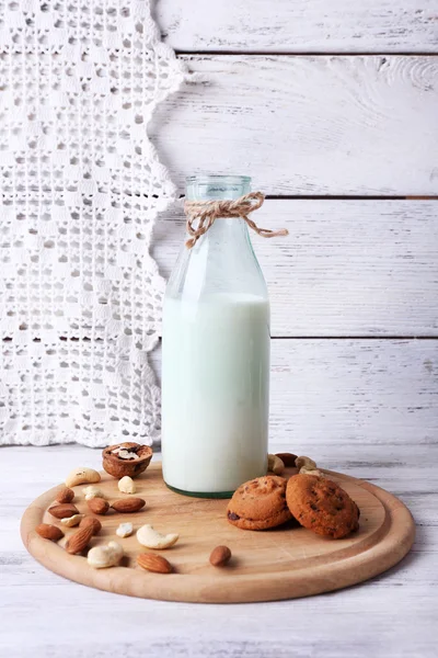 Melk in glaswerk met walnoten en cookies — Stockfoto