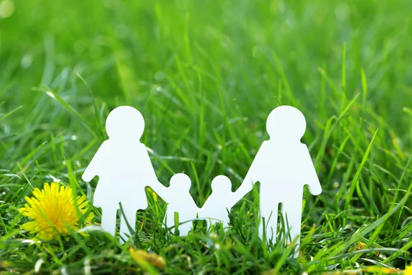 Cutout family over green grass — Stock Photo, Image