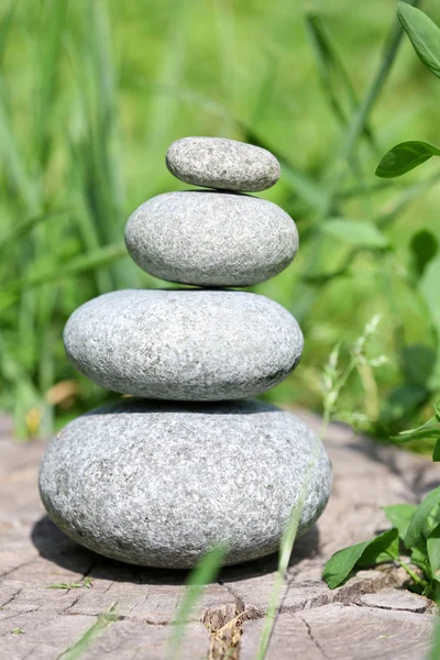 Stack of spa stones over green grass — Stock Photo, Image