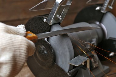 Bıçak bileyicisi ve bıçaklı bir el.