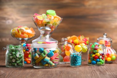 kavanoz masada ahşap arka plan üzerinde renkli şekerler