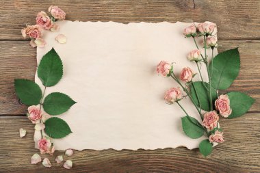 Ahşap masa, üstten görünüm üzerinde kağıt üzerine kurutulmuş güller