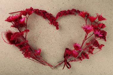 Kontrplak arka plan üzerinde kalp şeklinde kır çiçekleri