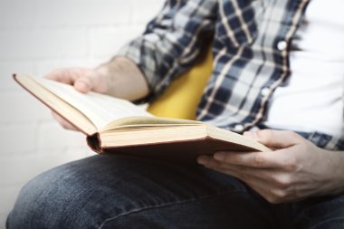 Genç adam kitap okuyor.