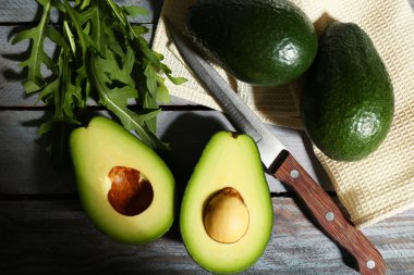 ahşap zemin üzerine dilimlenmiş avokado, roka