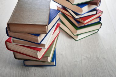 Ahşap zemin üzerine kitap yığınları