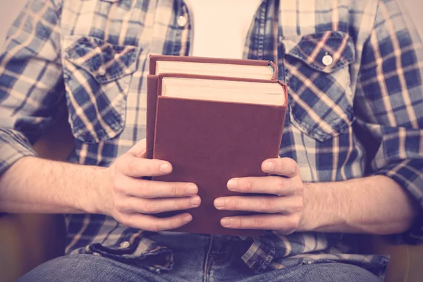 Young man holding books, close-up — Stock Photo, Image