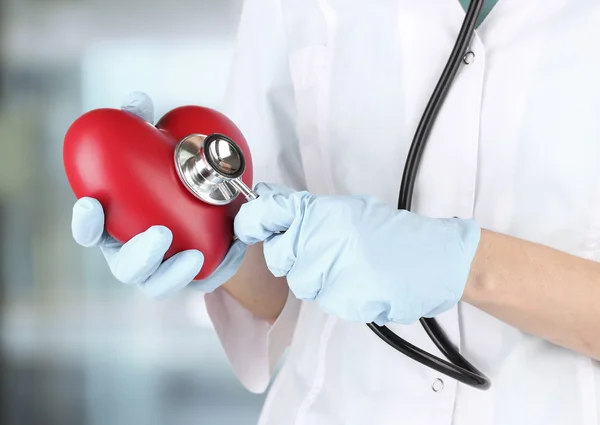 Stethoscope with heart in doctor hands, close up — Stock Photo, Image