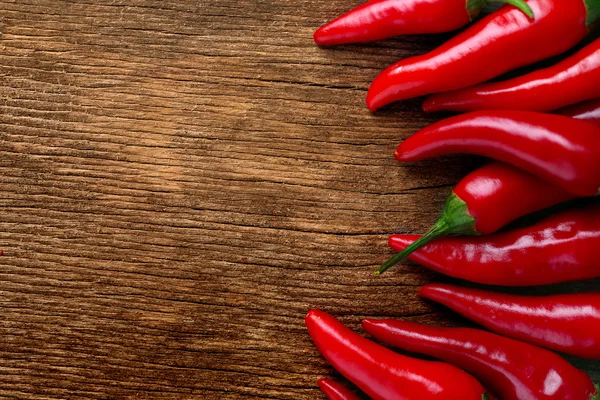 Červená horká chilli paprika na dřevěném pozadí — Stock fotografie