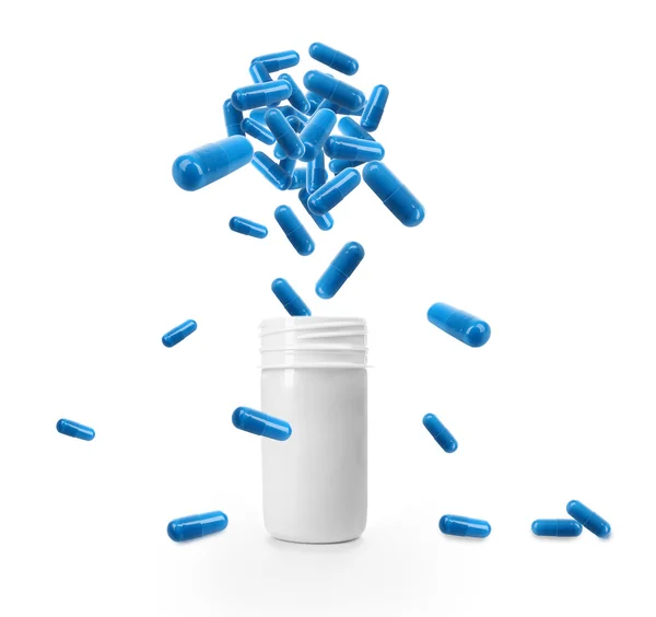 Medical pills falling into glass jar — Stock Photo, Image