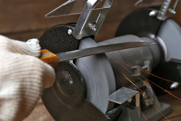 Bıçak bileyicisi ve bıçaklı bir el.