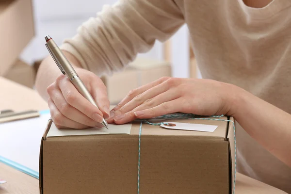 Женщина подписывает посылку на почте — стоковое фото