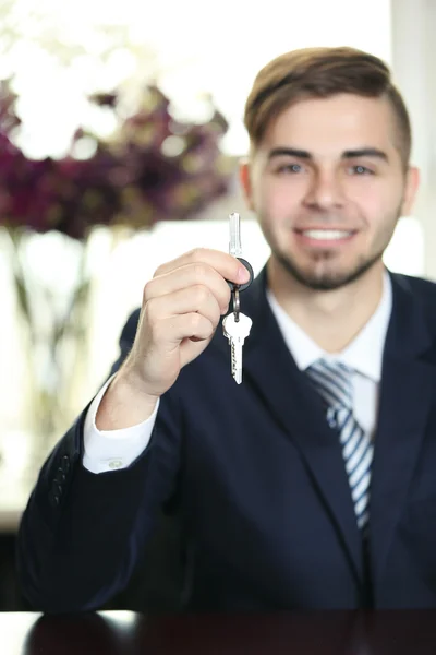 Porträtt av affärsman med nycklar i hand i office — Stockfoto