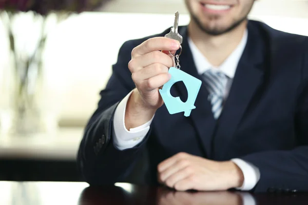 Πορτρέτο του επιχειρηματία με τα κλειδιά στο χέρι στο γραφείο σε θολή φόντο — Φωτογραφία Αρχείου