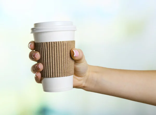 Mano femenina con taza de papel — Foto de Stock