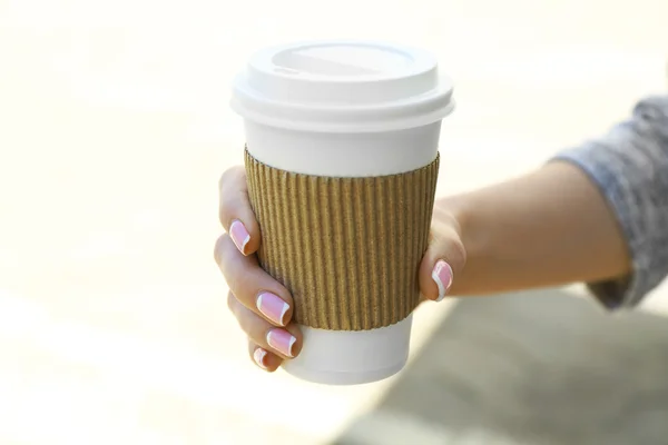 Женская рука с бумажной чашкой — стоковое фото