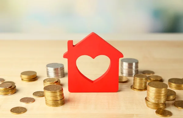 Modelo de casa con monedas sobre fondo brillante — Foto de Stock