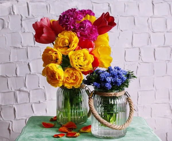 Schöne Blumen in Vasen auf Wandhintergrund — Stockfoto