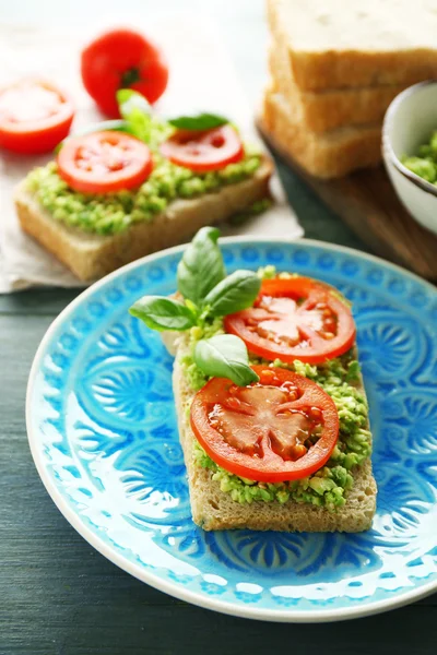 Vegetáriánus szendvics, avokádó és zöldség lemez, fából készült háttér — Stock Fotó