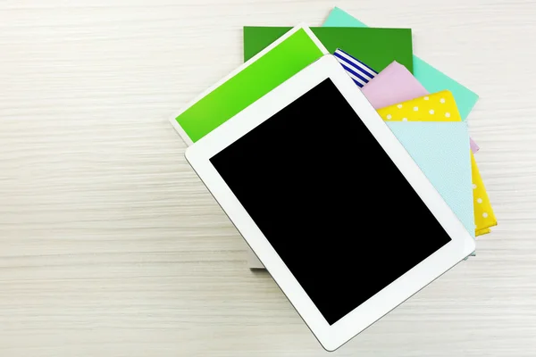 Notebook on top of pile of books and magazines on wooden background — Stock Photo, Image